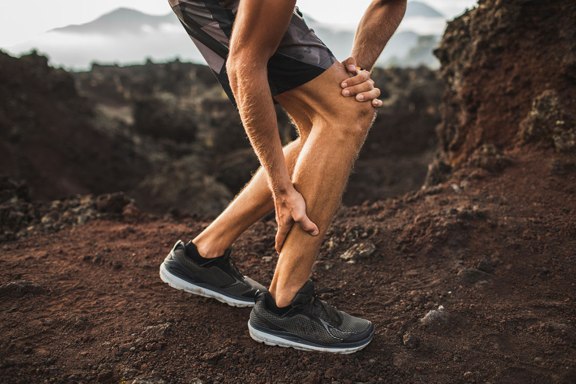 runner holding calf due to a calf strain