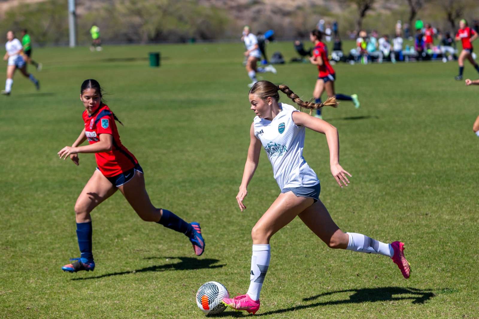 Young soccer player sprinting with the ball during a game