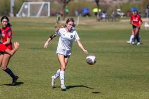 Young soccer player running onto the ball during a competitive match